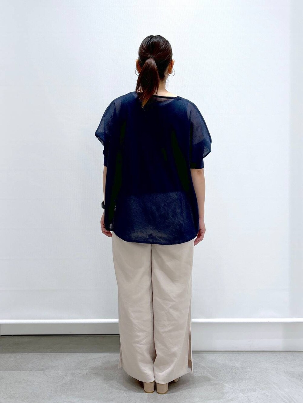 ベージュ系のその他パンツ、ベージュ系のサンダル、ブルー系のニット/セーターを着用したレディースの夏コーディネートの4枚目の写真