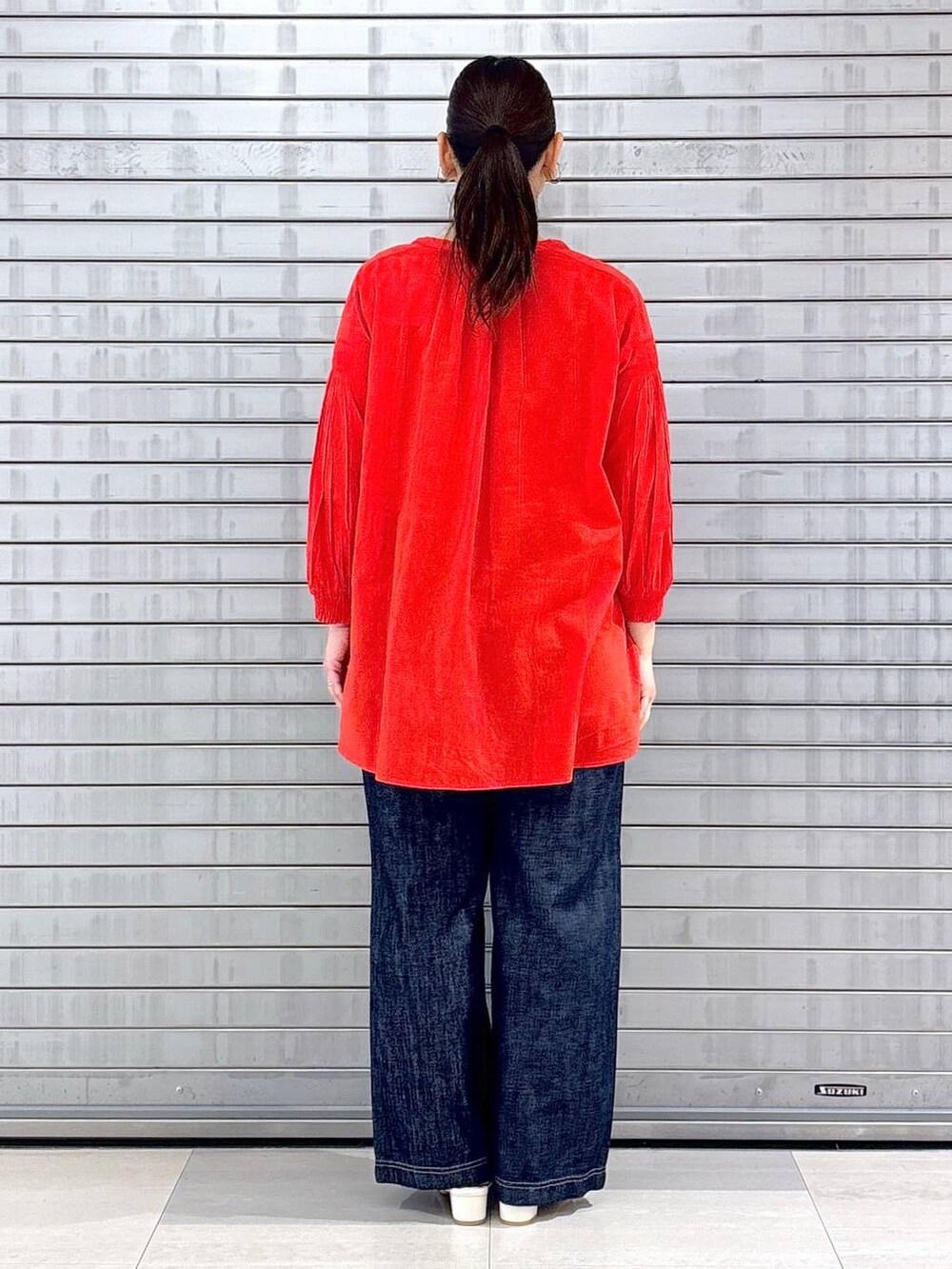 レッド系のシャツ/ブラウス、グレー系のその他パンツ、ホワイト系のハンドバッグを着用したレディースの春コーディネートの4枚目の写真