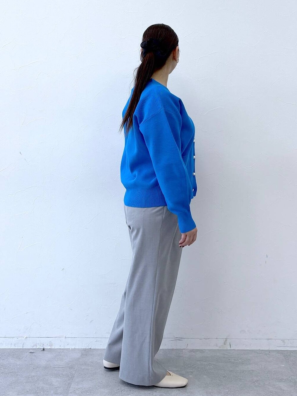 ホワイト系のパンプス、ホワイト系のハンドバッグ、グレー系のその他パンツを着用したレディースの冬コーディネートの5枚目の写真