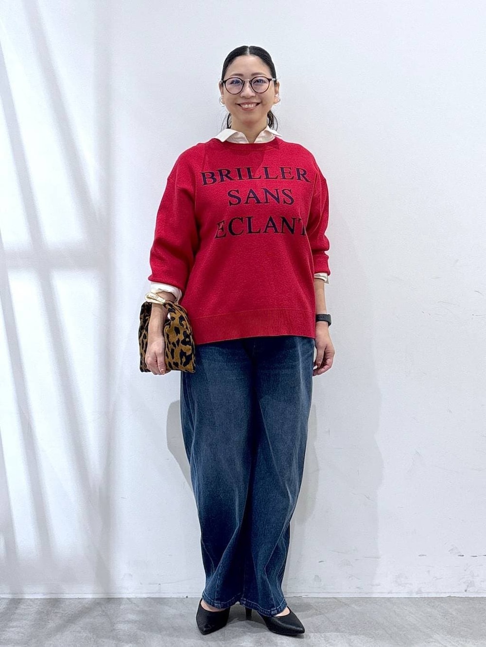 ブラック系のパンプス、ホワイト系のシャツ/ブラウス、ブルー系のデニムパンツを着用したレディースの秋コーディネートの2枚目の写真