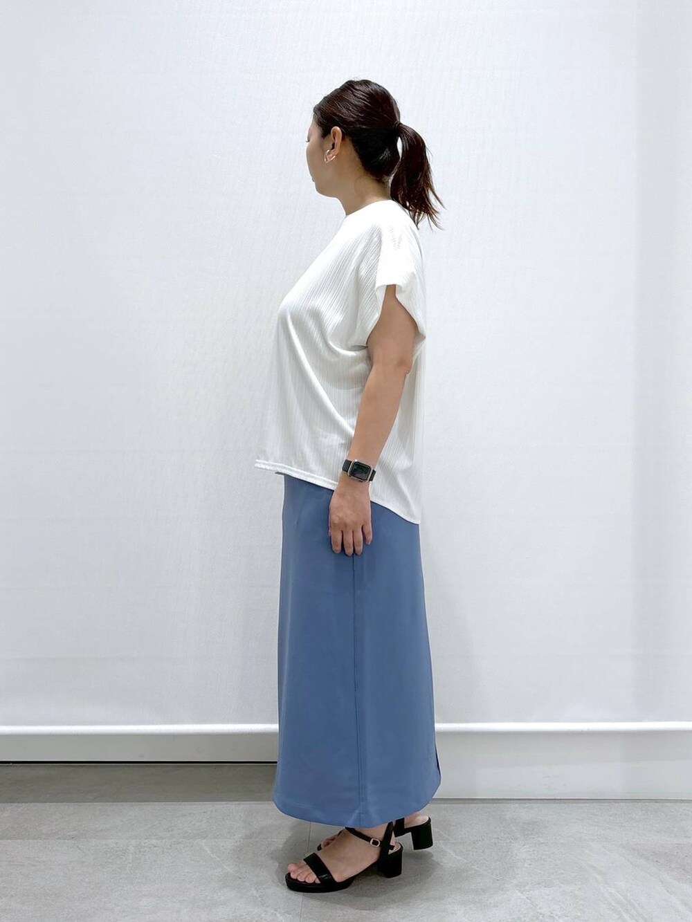 ホワイト系のTシャツ/カットソー、ブラック系のサンダル、ブルー系のスカートを着用したレディースの夏コーディネートの3枚目の写真