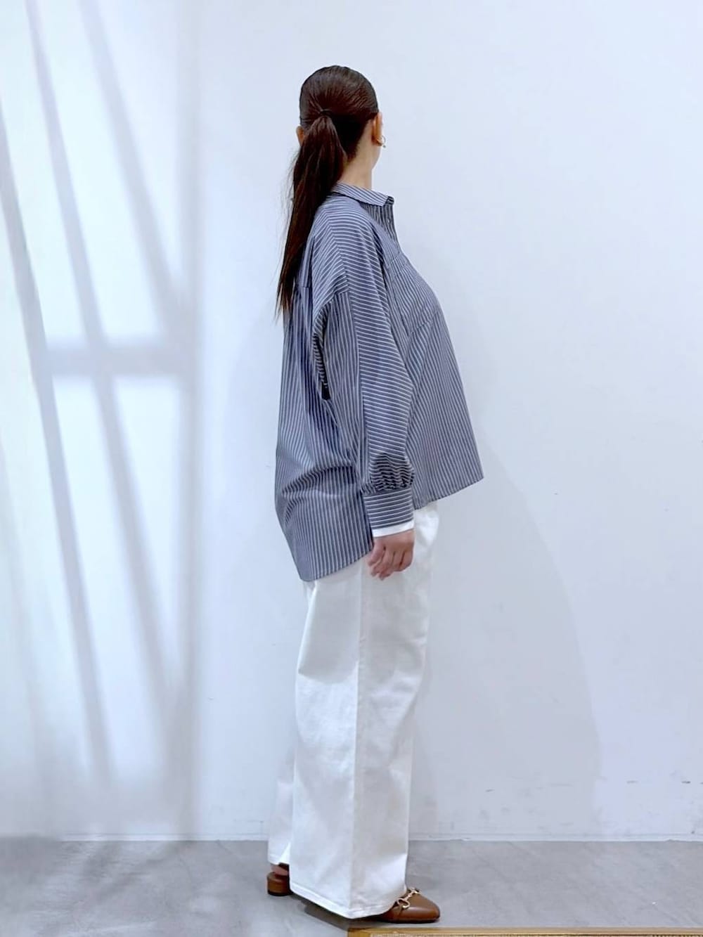 ホワイト系のデニムパンツ、イエロー系のハンドバッグ、ブルー系のシャツ/ブラウスを着用したレディースの春コーディネートの5枚目の写真