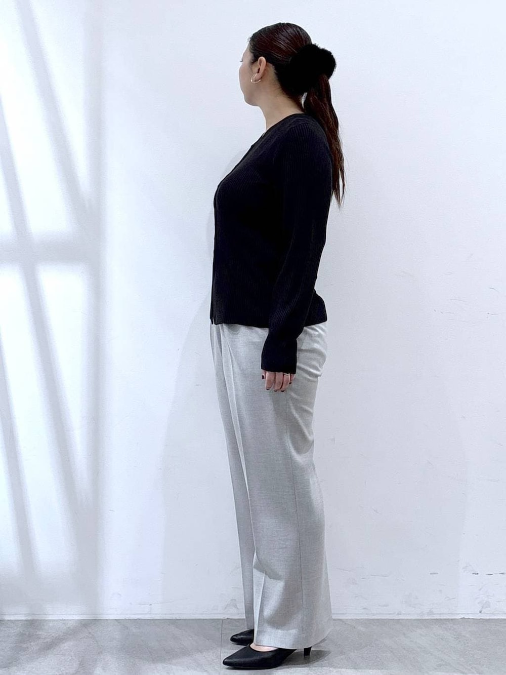 ブラック系のパンプス、グレー系のその他パンツ、ブラック系のカーディガン/ボレロを着用したレディースの冬コーディネートの3枚目の写真