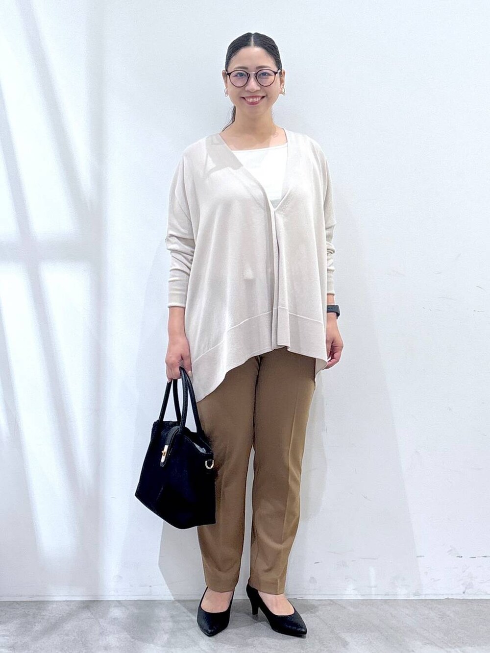 ブラック系のパンプス、ベージュ系のカーディガン/ボレロ、イエロー系のその他パンツを着用したレディースの秋コーディネートの2枚目の写真