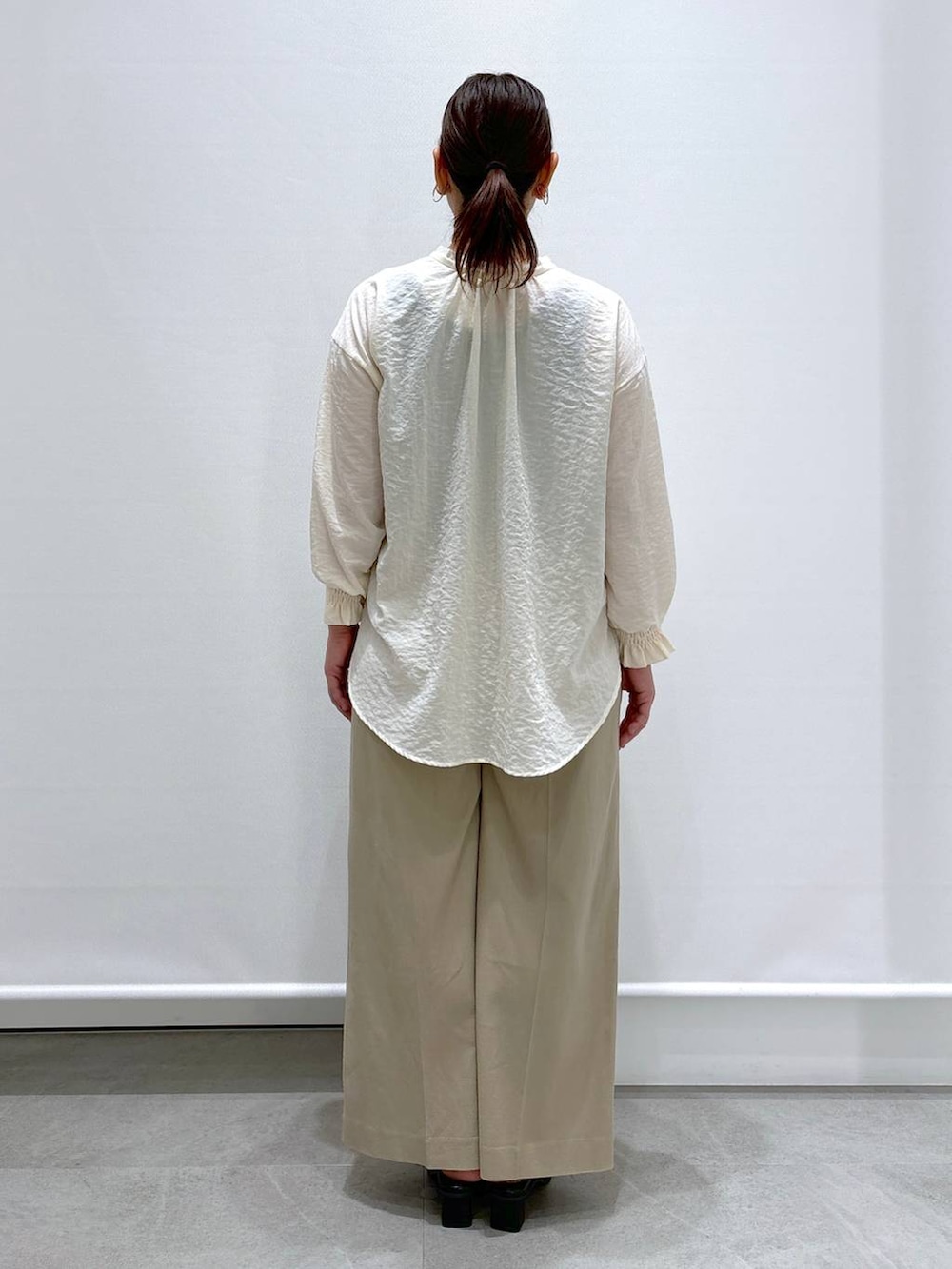 ベージュ系のその他パンツ、ブラック系のショルダーバッグ、ホワイト系のシャツ/ブラウスを着用したレディースの春コーディネートの4枚目の写真