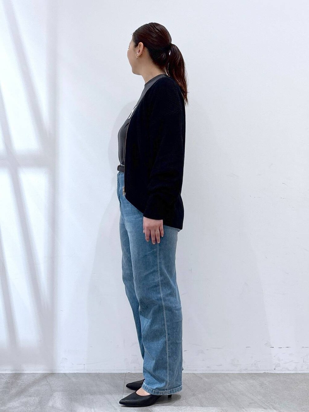 ブルー系のデニムパンツ、ブラック系のカーディガン/ボレロ、グレー系のTシャツ/カットソーを着用したレディースの春コーディネートの3枚目の写真