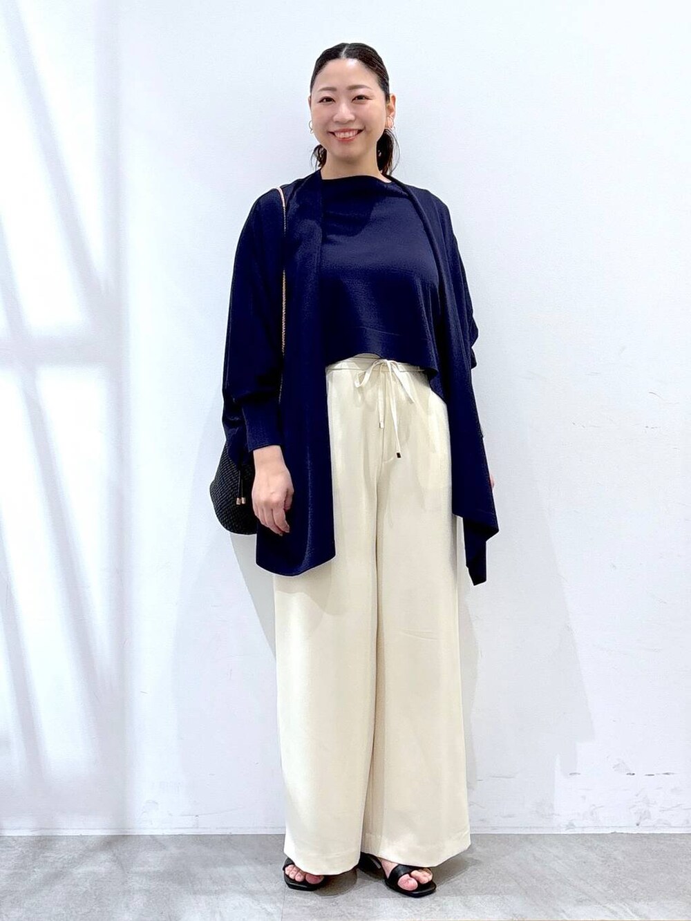 ブルー系のニット/セーター、ブルー系のカーディガン/ボレロ、ホワイト系のその他パンツを着用したレディースの春コーディネートの2枚目の写真