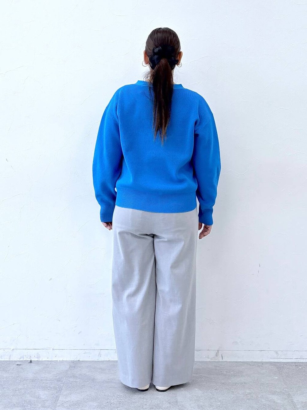 ホワイト系のパンプス、ホワイト系のハンドバッグ、グレー系のその他パンツを着用したレディースの冬コーディネートの4枚目の写真