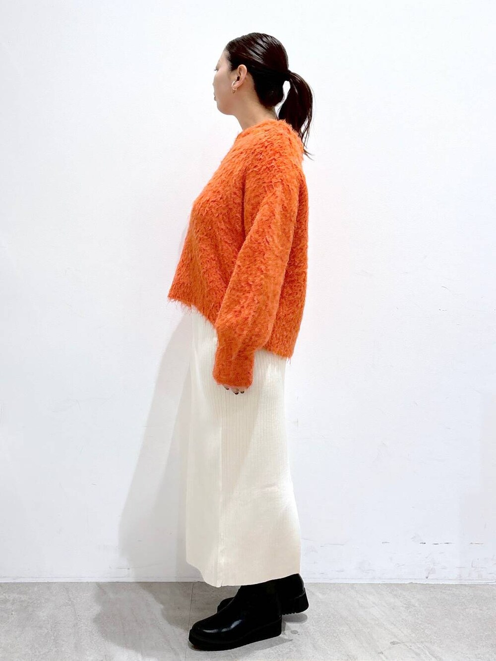 ブラック系のブーツ、ホワイト系のスカート、ホワイト系のスカートを着用したレディースの秋コーディネートの3枚目の写真