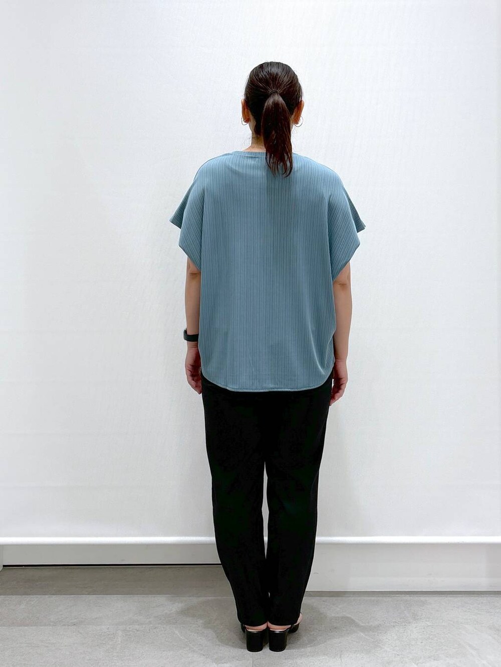 ゴールド系のトートバッグ、ブラック系のその他パンツ、グリーン系のTシャツ/カットソーを着用したレディースの秋コーディネートの4枚目の写真
