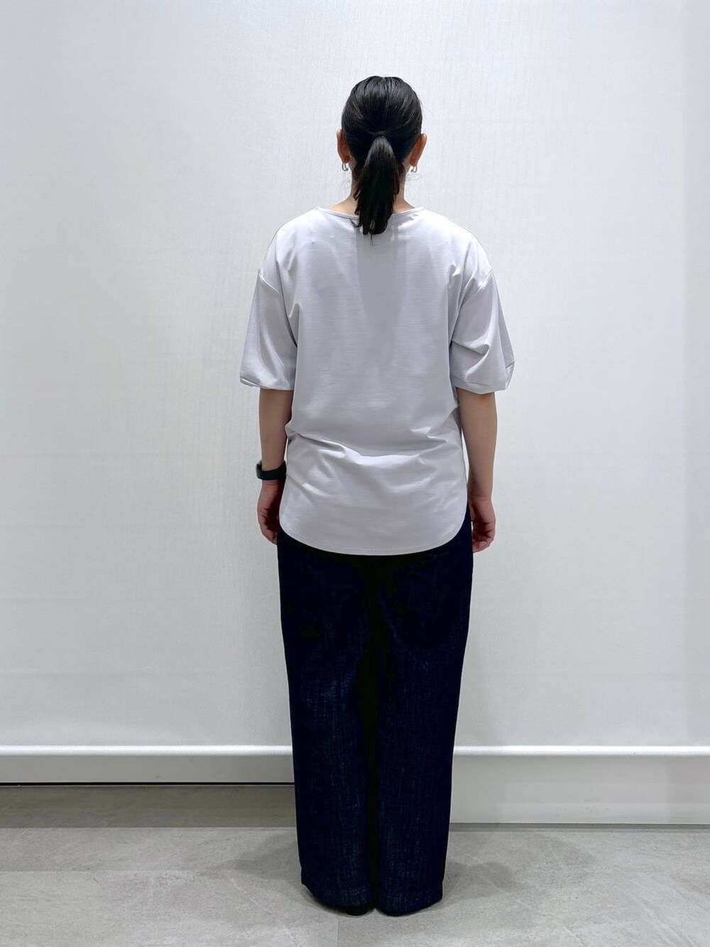 グレー系のTシャツ/カットソー、ブルー系のデニムパンツ、ブラック系のサンダルを着用したレディースの夏コーディネートの4枚目の写真