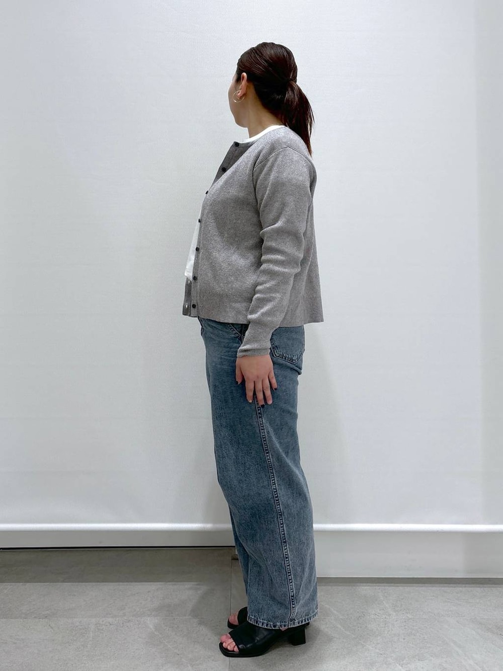 グレー系のカーディガン/ボレロ、ブルー系のデニムパンツ、ブラック系のサンダルを着用したレディースの春コーディネートの3枚目の写真