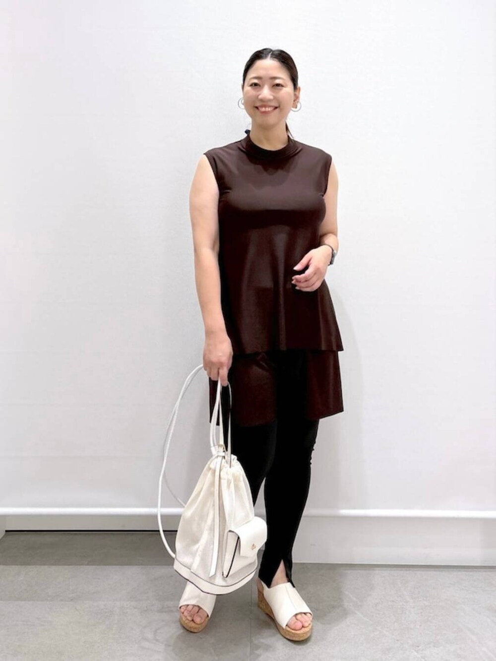 ホワイト系のサンダルを着用したレディースの夏コーディネートの2枚目の写真