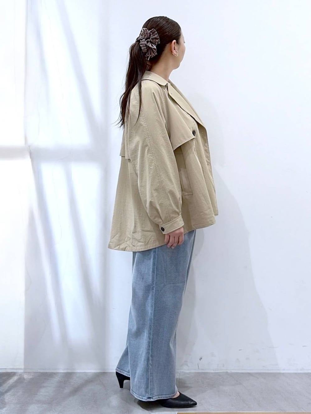 ホワイト系のニット/セーター、ブルー系のデニムパンツ、ブラック系のハンドバッグを着用したレディースの春コーディネートの5枚目の写真