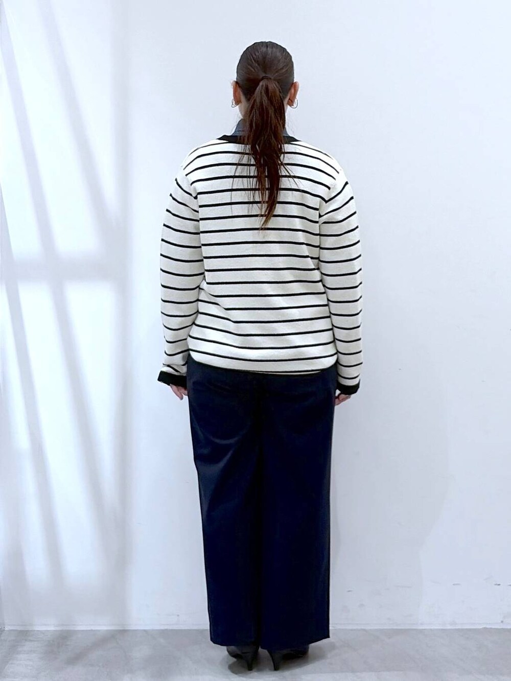 ブラック系のハンドバッグ、ブルー系のその他パンツ、ホワイト系のカーディガン/ボレロを着用したレディースの春コーディネートの5枚目の写真