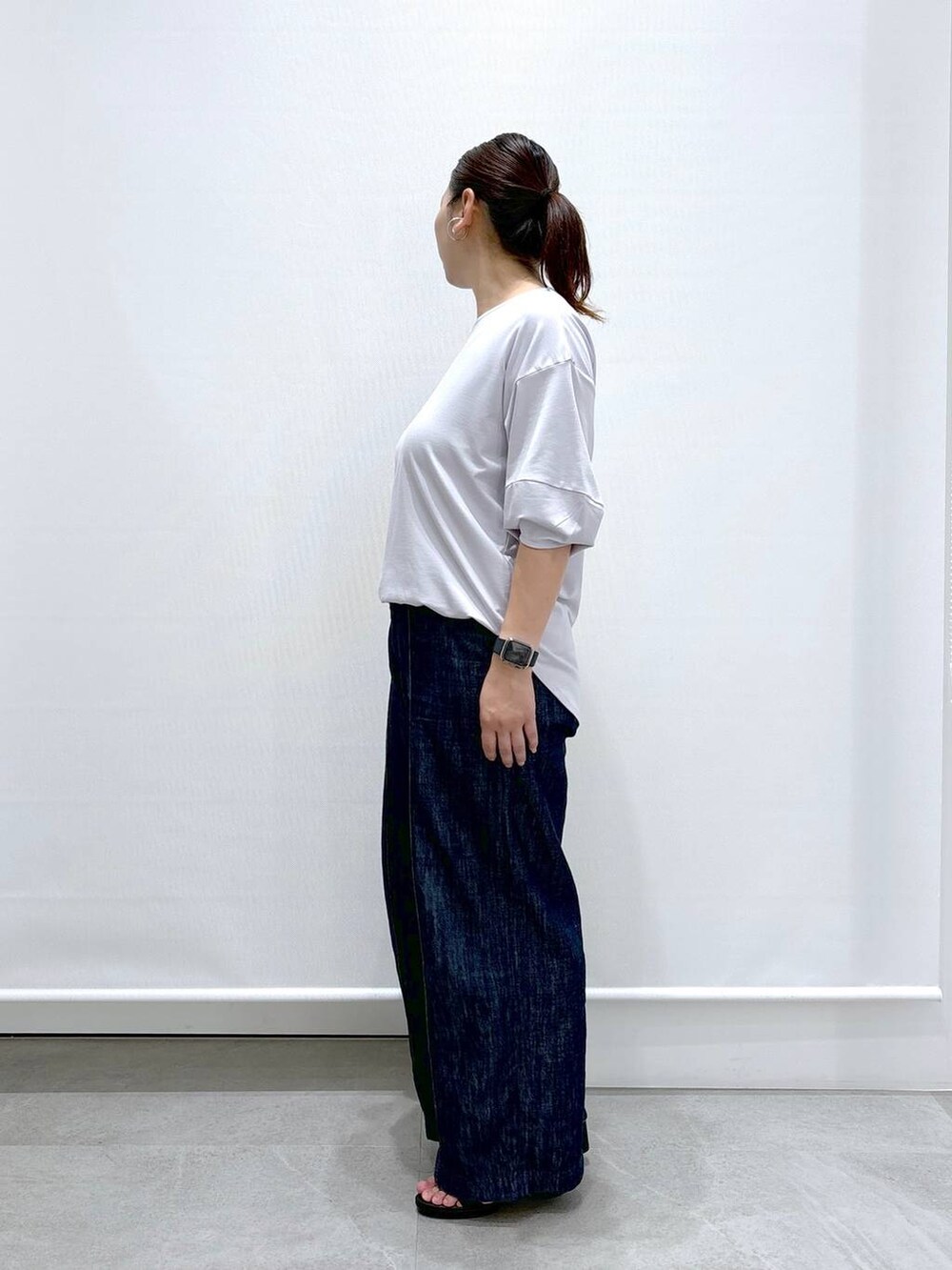 グレー系のTシャツ/カットソー、ブルー系のデニムパンツ、ブラック系のサンダルを着用したレディースの夏コーディネートの3枚目の写真