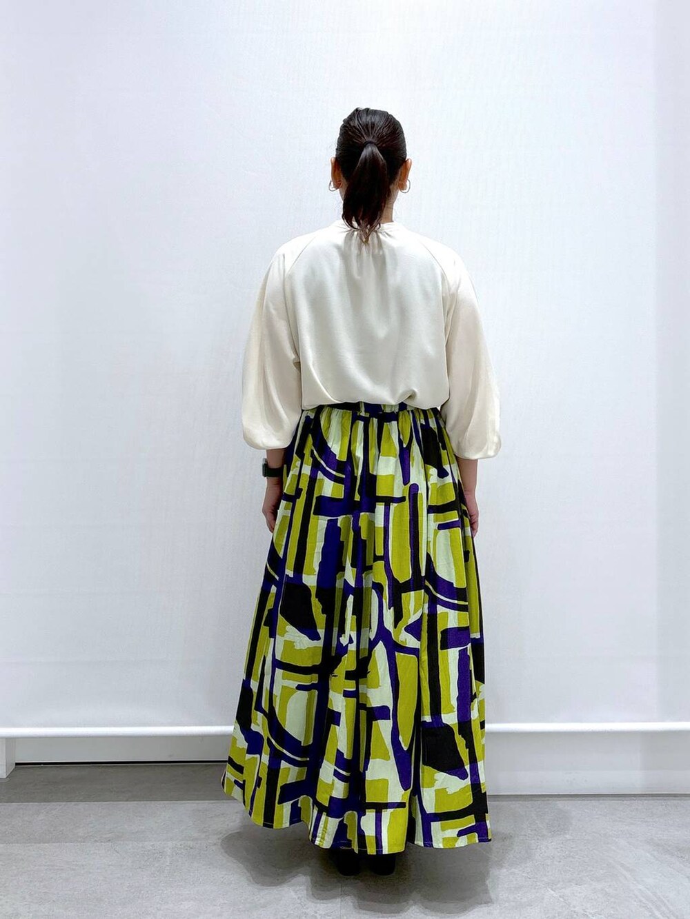 ブラック系のショルダーバッグ、ブラック系のサンダル、ホワイト系のシャツ/ブラウスを着用したレディースの夏コーディネートの4枚目の写真