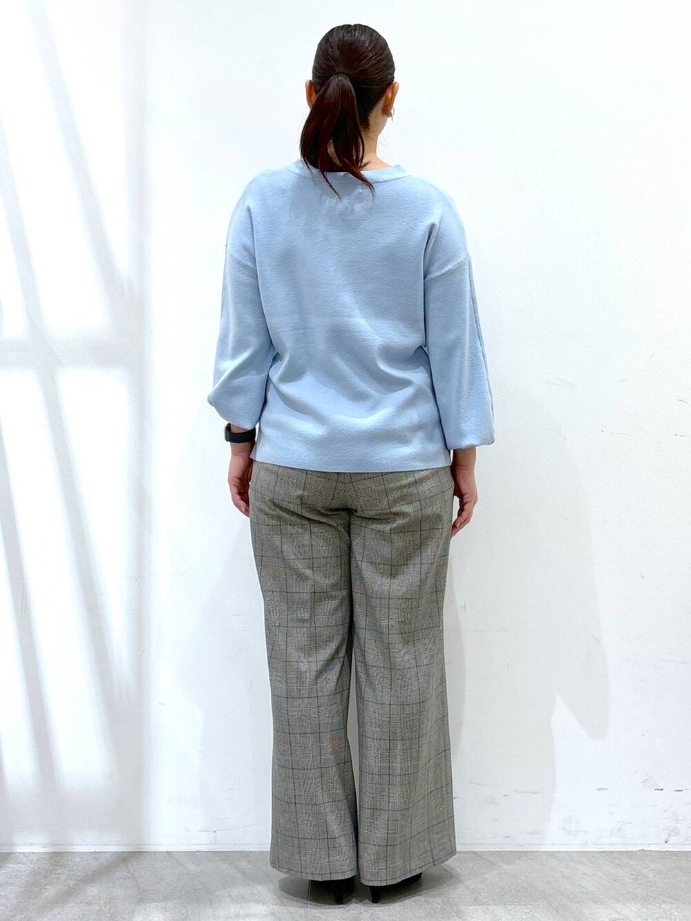 グレー系のその他パンツ、ブラック系のその他パンツ、ブルー系のニット/セーターを着用したレディースの冬コーディネートの4枚目の写真