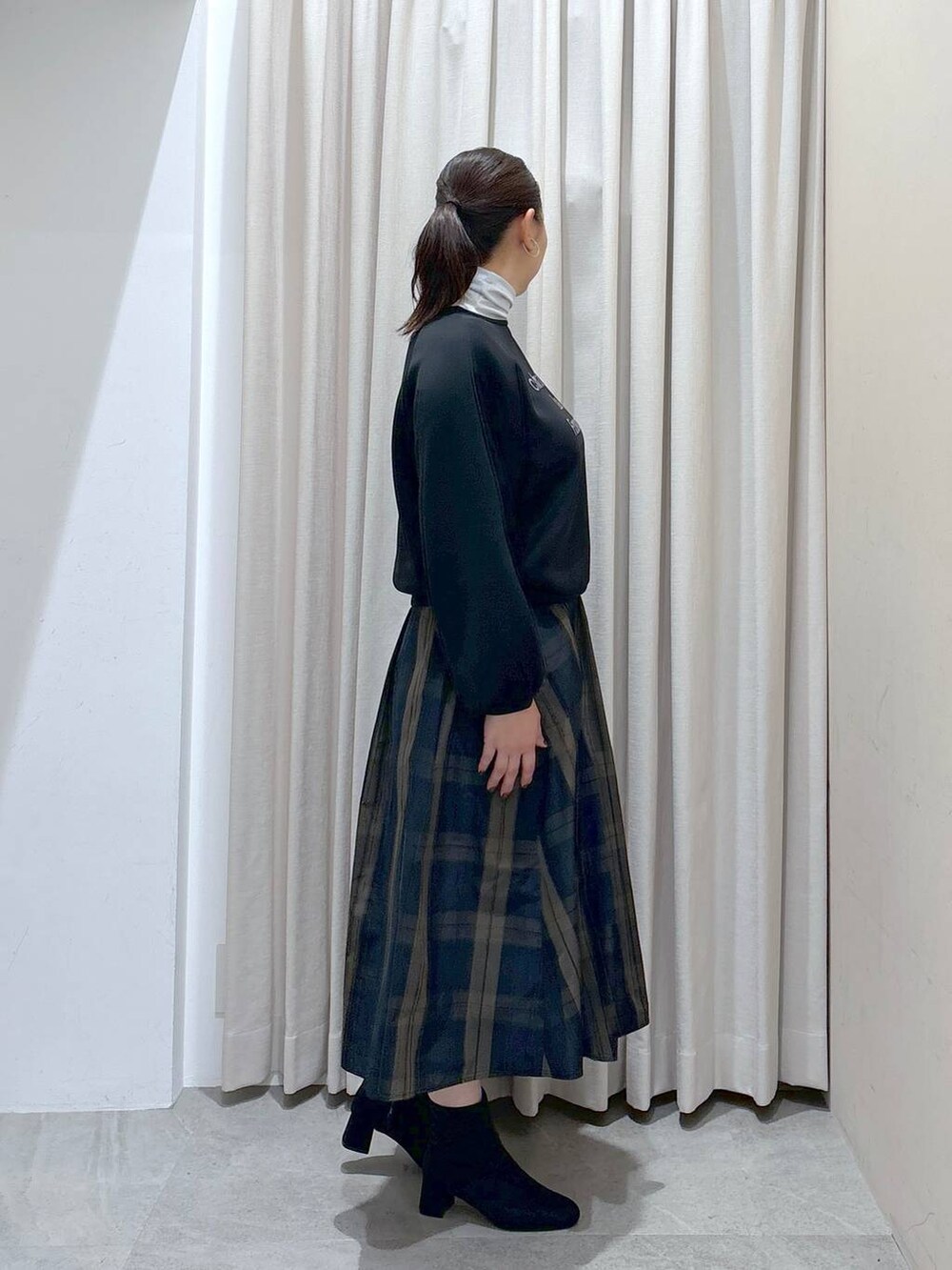 ブラック系のスウェット、ホワイト系のTシャツ/カットソー、グレー系のブーツを着用したレディースの秋コーディネートの5枚目の写真