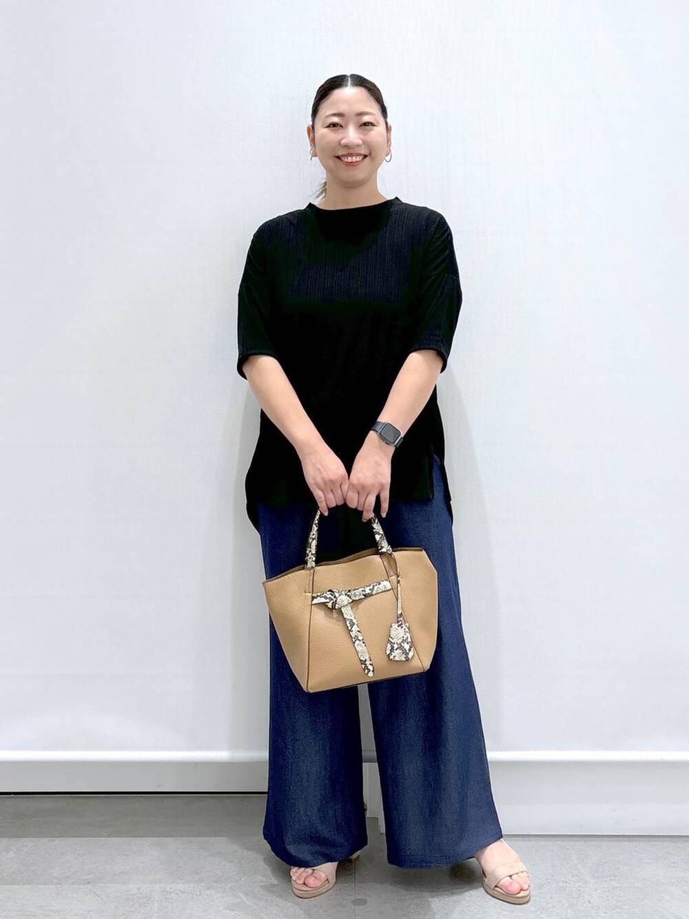 ブルー系のデニムパンツ、ベージュ系のサンダル、ブルー系のデニムパンツを着用したレディースの夏コーディネートの2枚目の写真