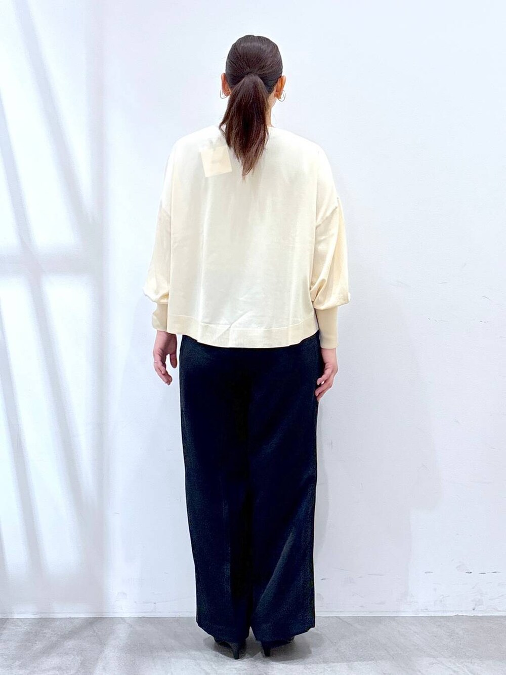 ホワイト系のニット/セーター、ブルー系のその他パンツを着用したレディースの春コーディネートの4枚目の写真