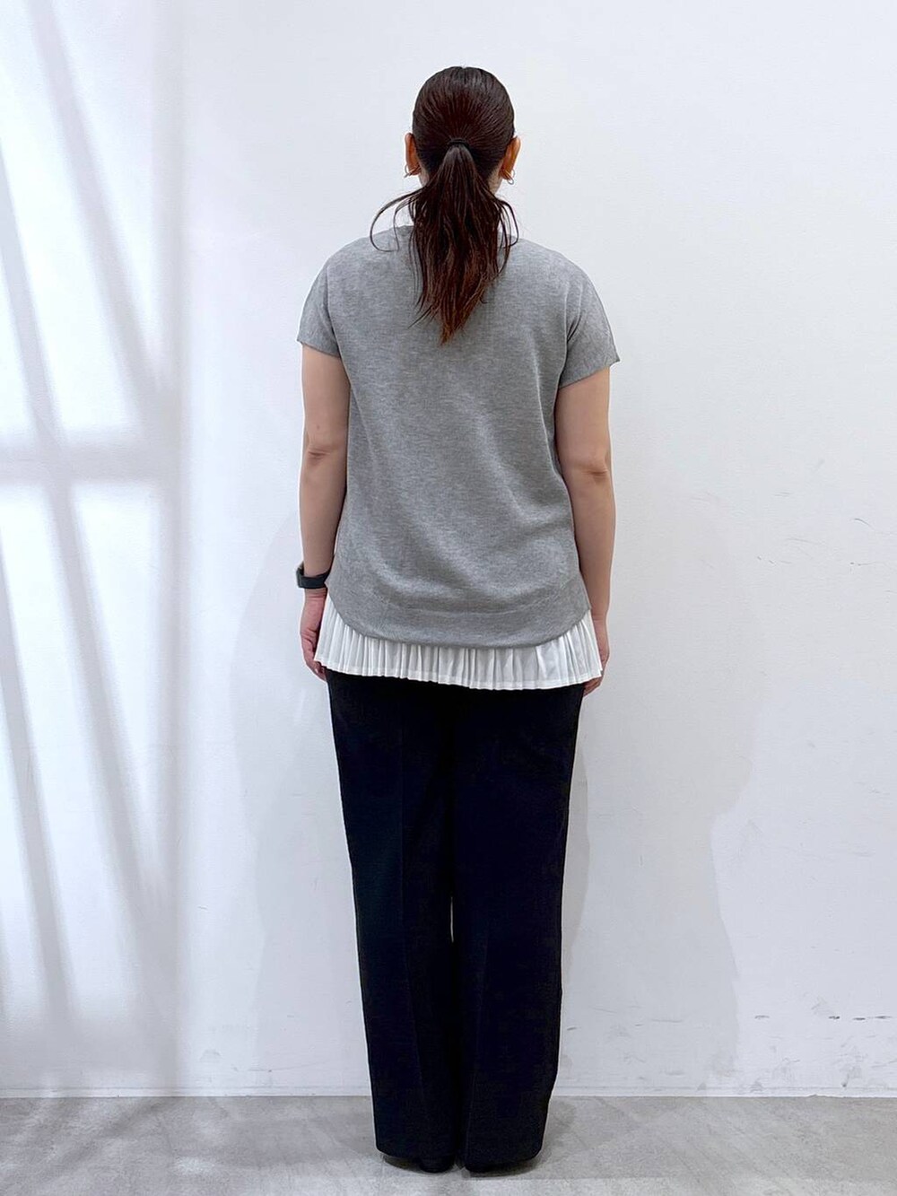 ホワイト系のタンクトップ、ブラック系のハンドバッグ、ブラック系のその他パンツを着用したレディースの夏コーディネートの4枚目の写真