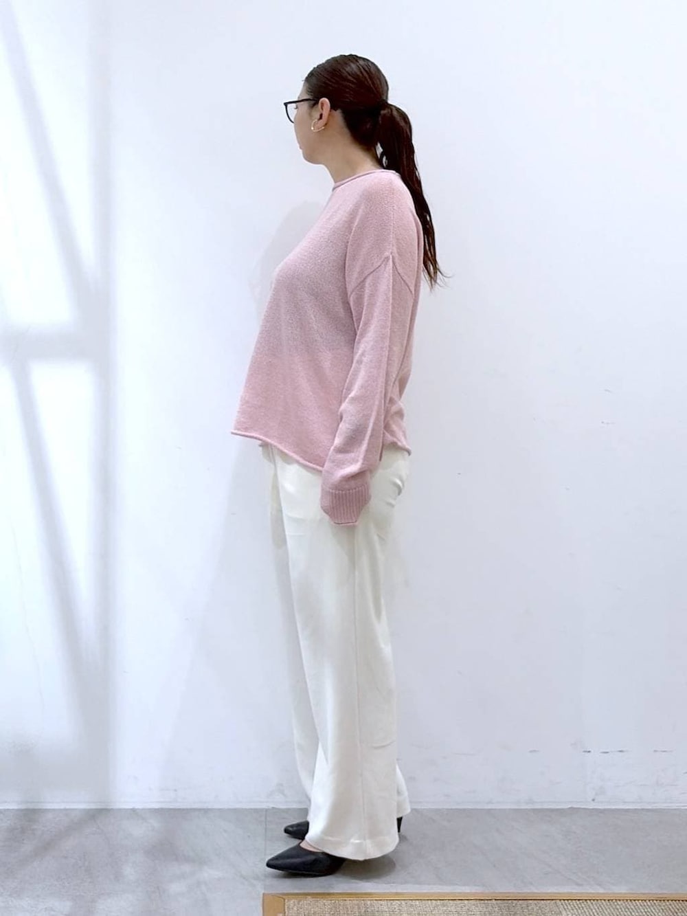 ブラック系のその他パンツ、ピンク系のニット/セーター、ブラック系のハンドバッグを着用したレディースの春コーディネートの3枚目の写真