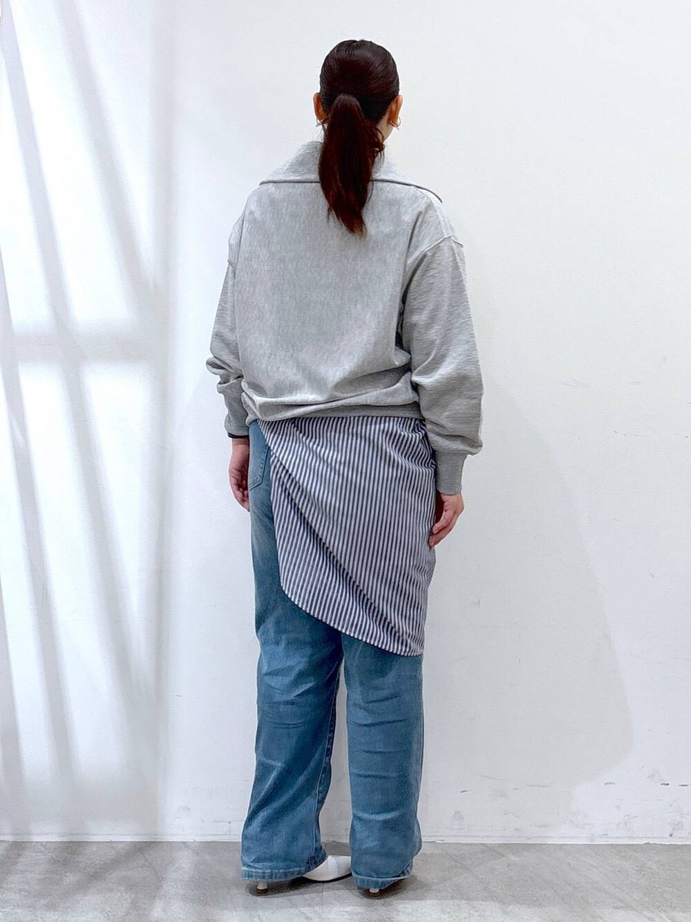 ホワイト系のハンドバッグ、ブルー系のデニムパンツ、グレー系のTシャツ/カットソーを着用したレディースの春コーディネートの5枚目の写真