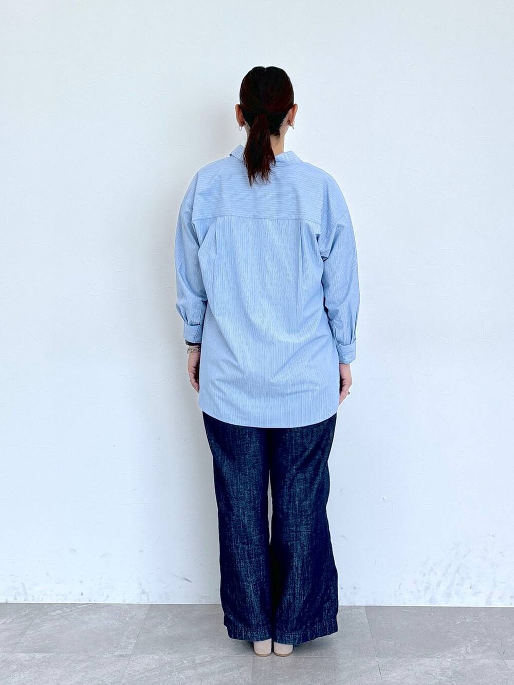 ブルー系のデニムパンツ、ホワイト系のシャツ/ブラウス、ベージュ系のサンダルを着用したレディースの夏コーディネートの4枚目の写真