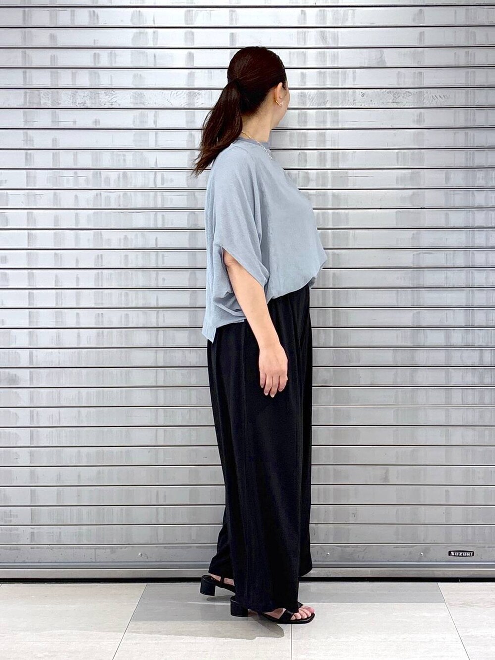 ブラック系のハンドバッグ、ブルー系のTシャツ/カットソー、ブラック系のその他パンツを着用したレディースの春コーディネートの5枚目の写真