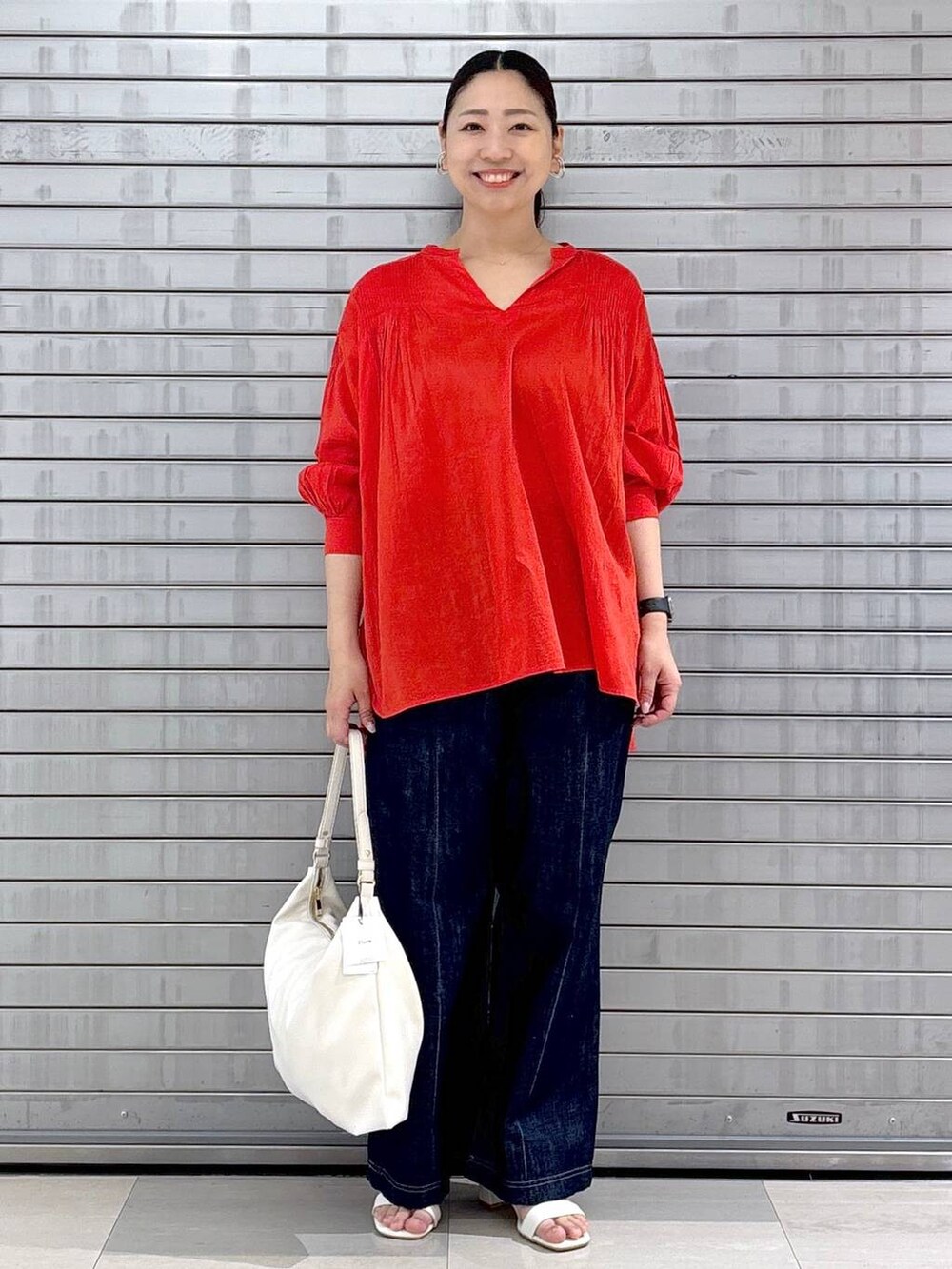 レッド系のシャツ/ブラウス、グレー系のその他パンツ、ホワイト系のハンドバッグを着用したレディースの春コーディネートの2枚目の写真