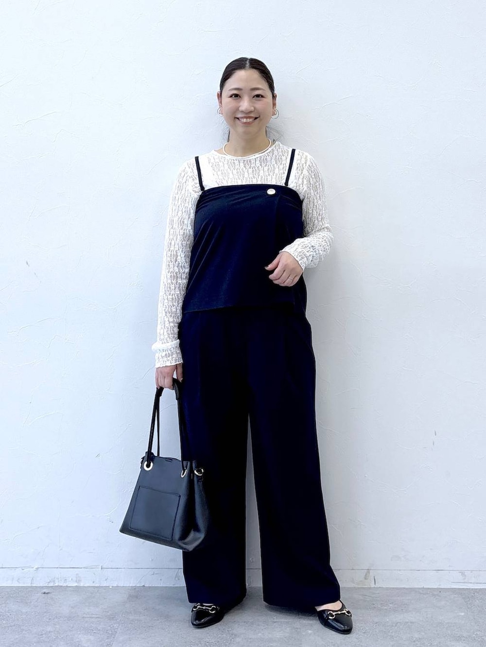 ブラック系のパンプス、ブラック系のトートバッグ、ブルー系のその他パンツを着用したレディースの冬コーディネートの2枚目の写真