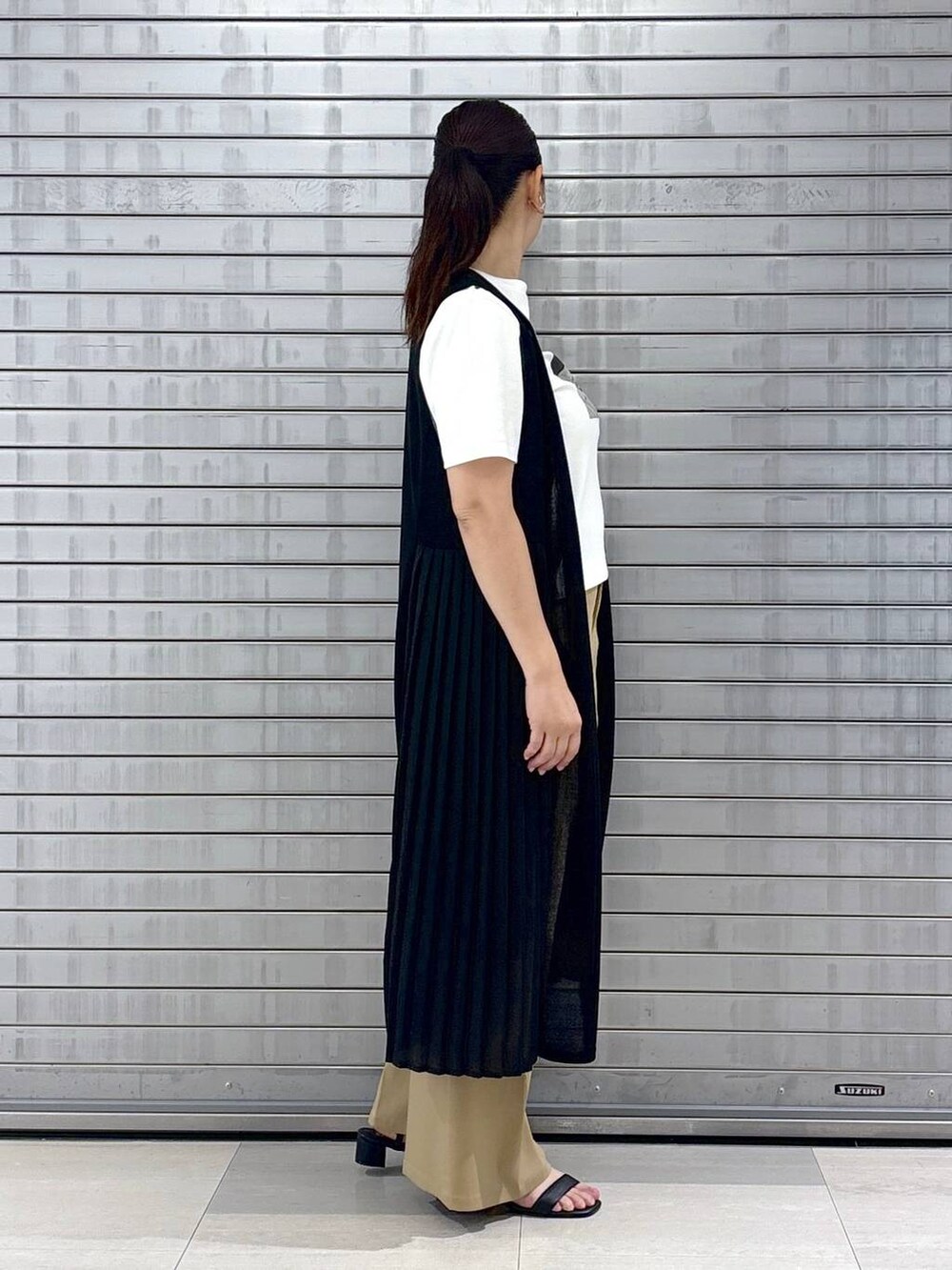 ブラック系のハンドバッグ、ホワイト系のTシャツ/カットソー、ブラウン系のその他パンツを着用したレディースの春コーディネートの5枚目の写真