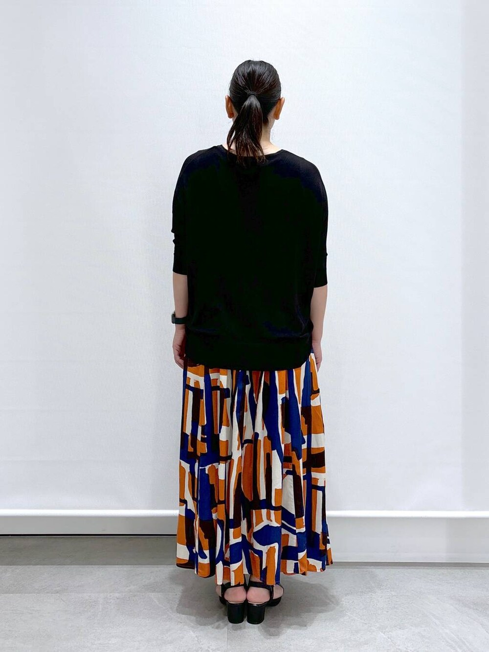 ブラック系のショルダーバッグ、ブラック系のサンダル、ブラック系のニット/セーターを着用したレディースの夏コーディネートの5枚目の写真