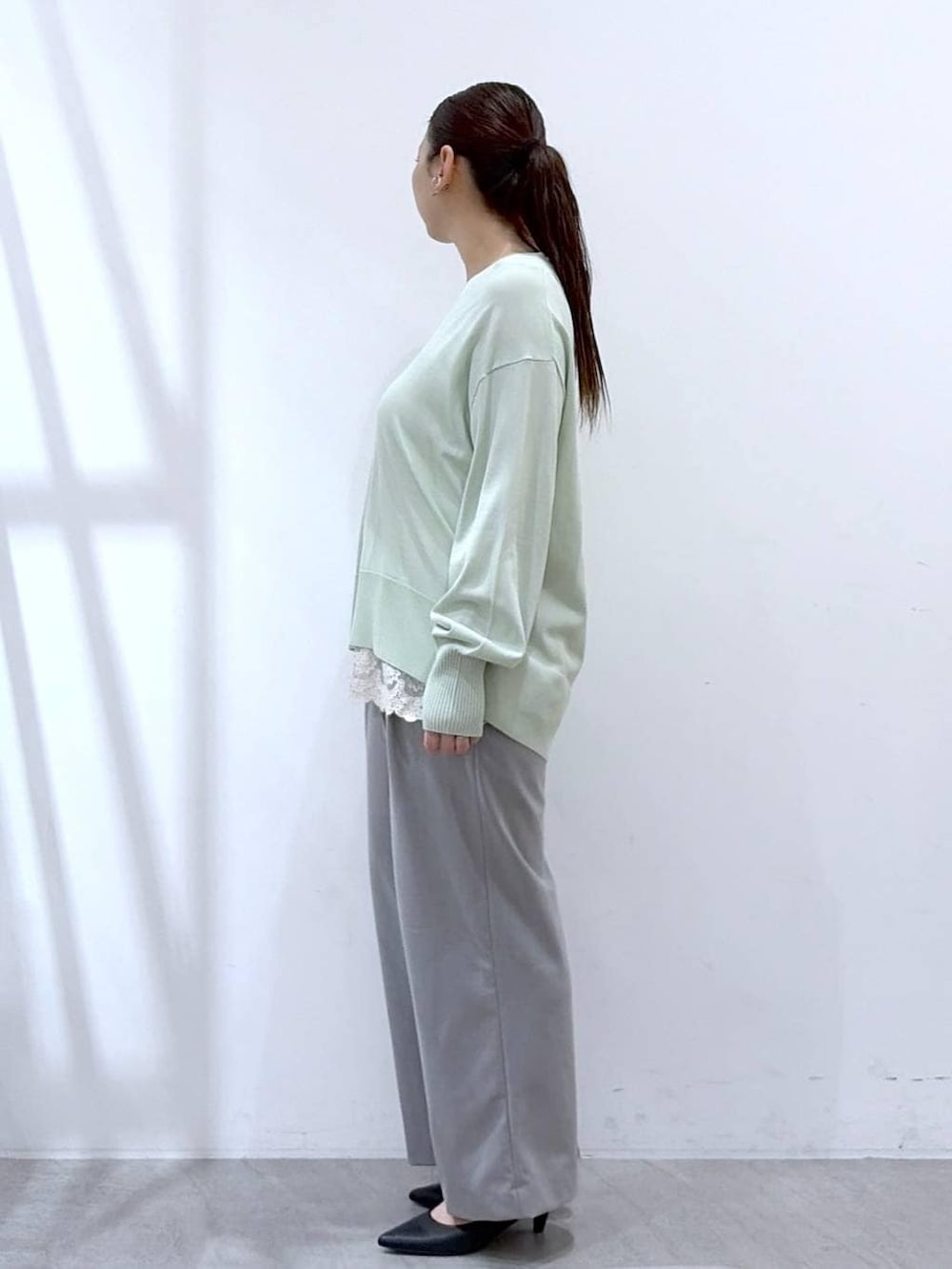 ホワイト系のタンクトップ、ブラック系のハンドバッグ、グレー系のその他パンツを着用したレディースの春コーディネートの3枚目の写真