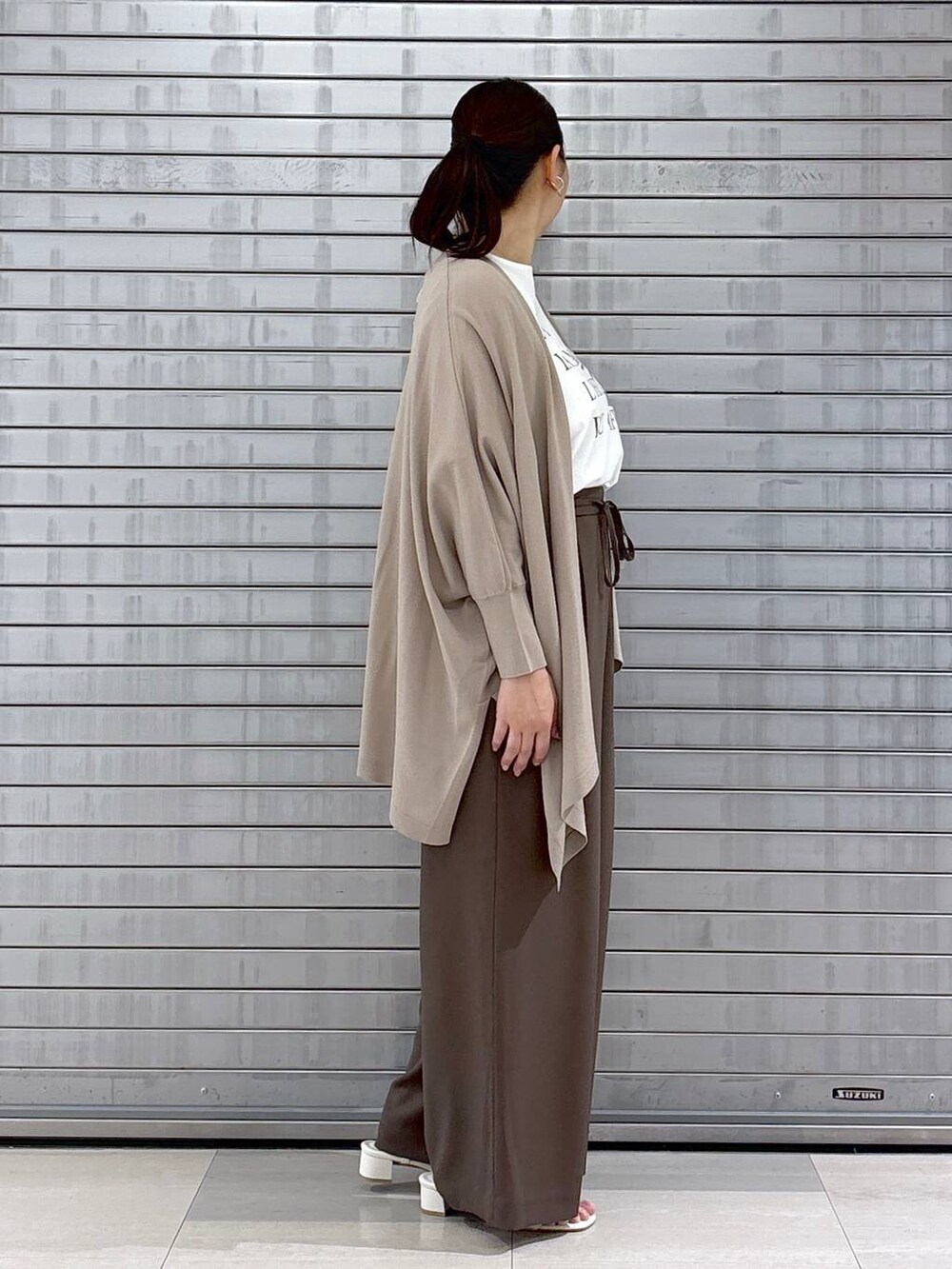 ベージュ系のハンドバッグ、ブラウン系のその他パンツ、ホワイト系のTシャツ/カットソーを着用したレディースの春コーディネートの5枚目の写真