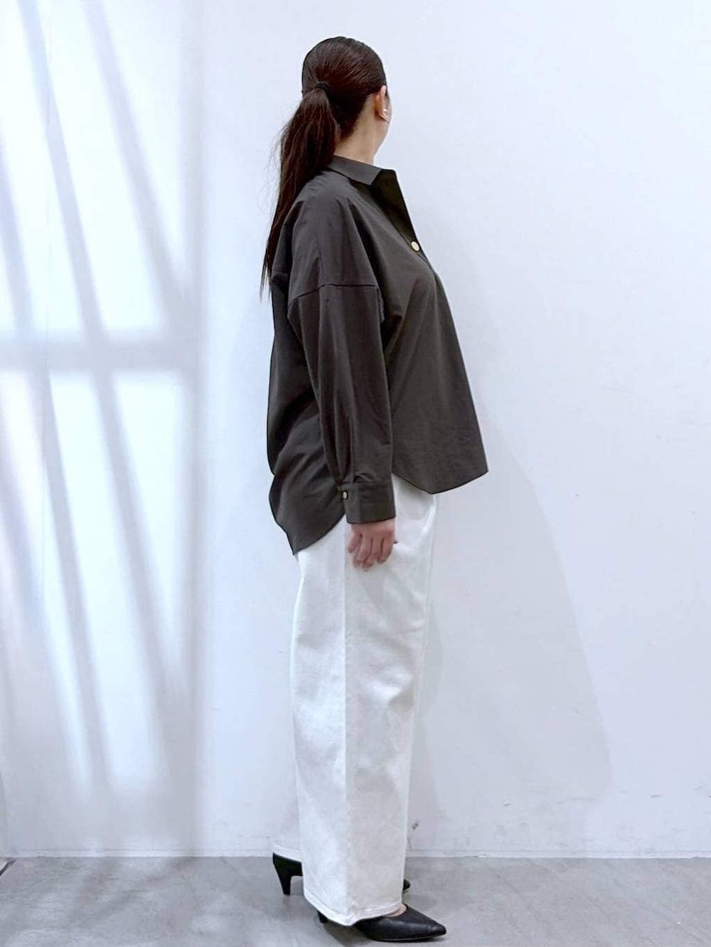 ホワイト系のデニムパンツ、ブラック系のハンドバッグ、ブラウン系のシャツ/ブラウスを着用したレディースの春コーディネートの5枚目の写真