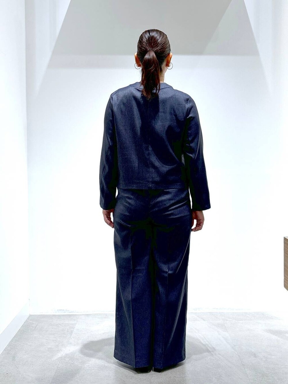 ブルー系のデニムパンツ、ブルー系のデニムパンツ、ブラック系のパンプスを着用したレディースの秋コーディネートの4枚目の写真