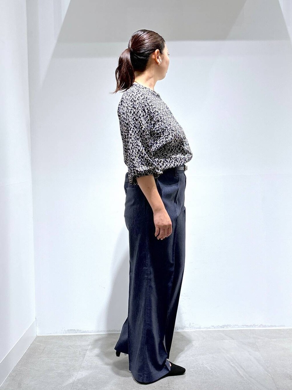 ブラック系のトートバッグ、ブラック系のパンプス、ブルー系のデニムパンツを着用したレディースの秋コーディネートの5枚目の写真