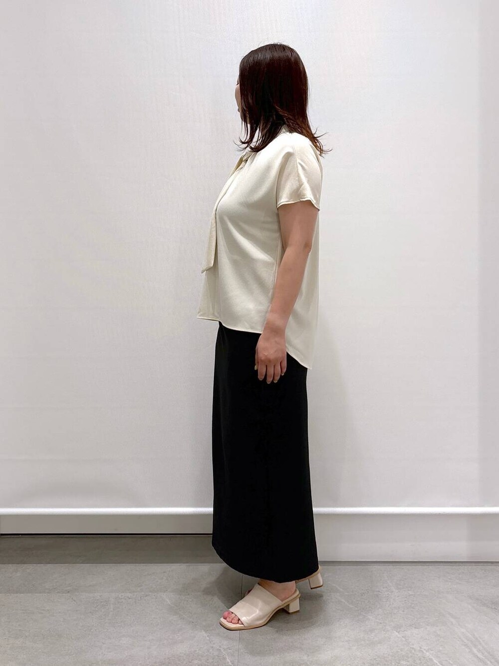 ホワイト系のシャツ/ブラウス、ホワイト系のサンダル、ブラック系のスカートを着用したレディースの夏コーディネートの3枚目の写真