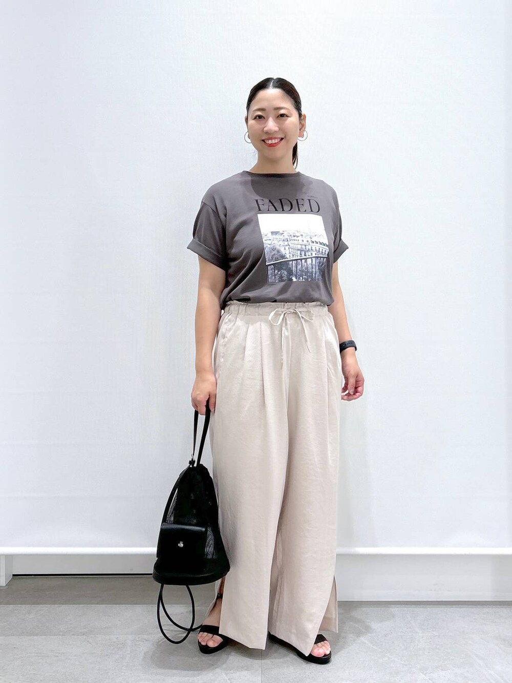 ベージュ系のその他パンツ、ブラック系のサンダル、グレー系のTシャツ/カットソーを着用したレディースの夏コーディネートの2枚目の写真