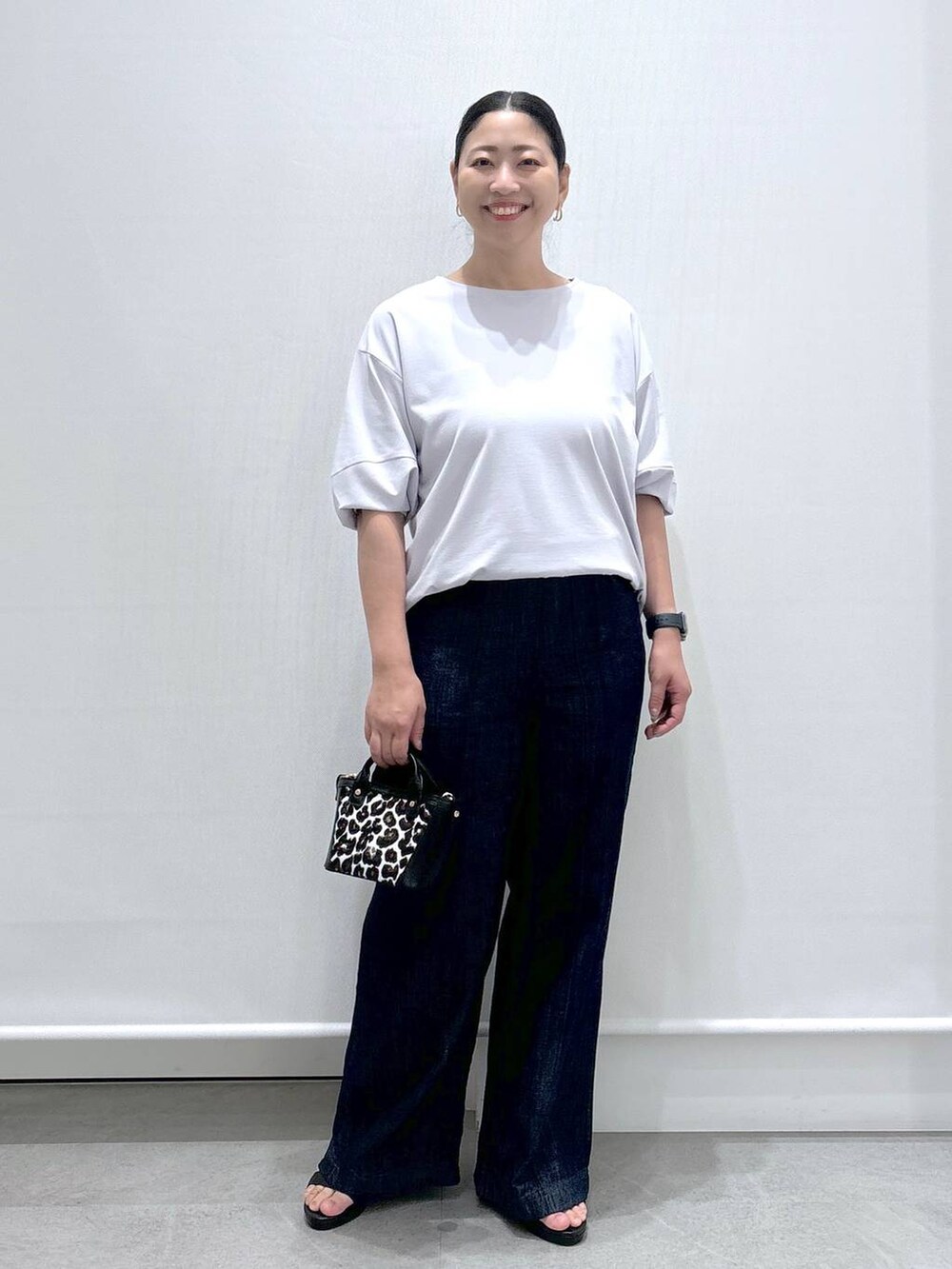 グレー系のTシャツ/カットソー、ブルー系のデニムパンツ、ブラック系のサンダルを着用したレディースの夏コーディネートの2枚目の写真