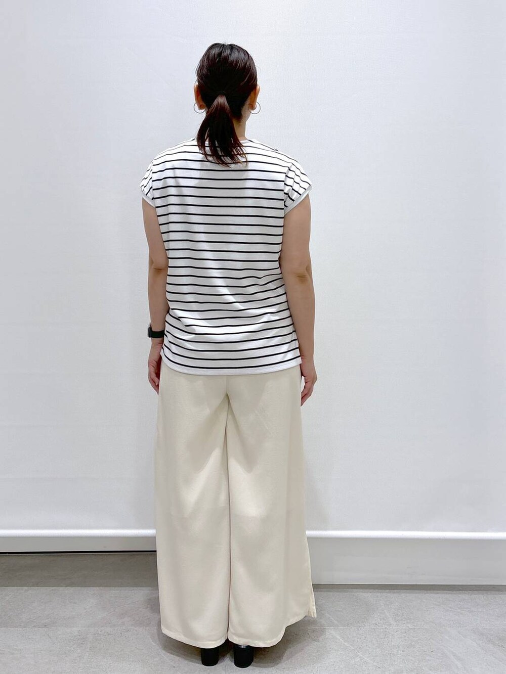 ブラック系のTシャツ/カットソー、ホワイト系のその他パンツ、シルバー系のショルダーバッグを着用したレディースの夏コーディネートの4枚目の写真