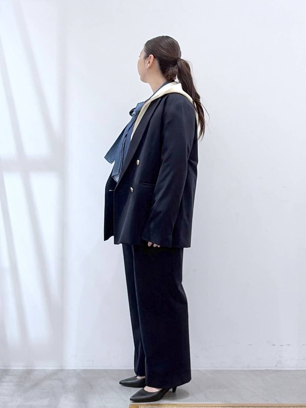 ブラック系のハンドバッグ、ホワイト系のパーカー、ブルー系のその他パンツを着用したレディースの春コーディネートの3枚目の写真