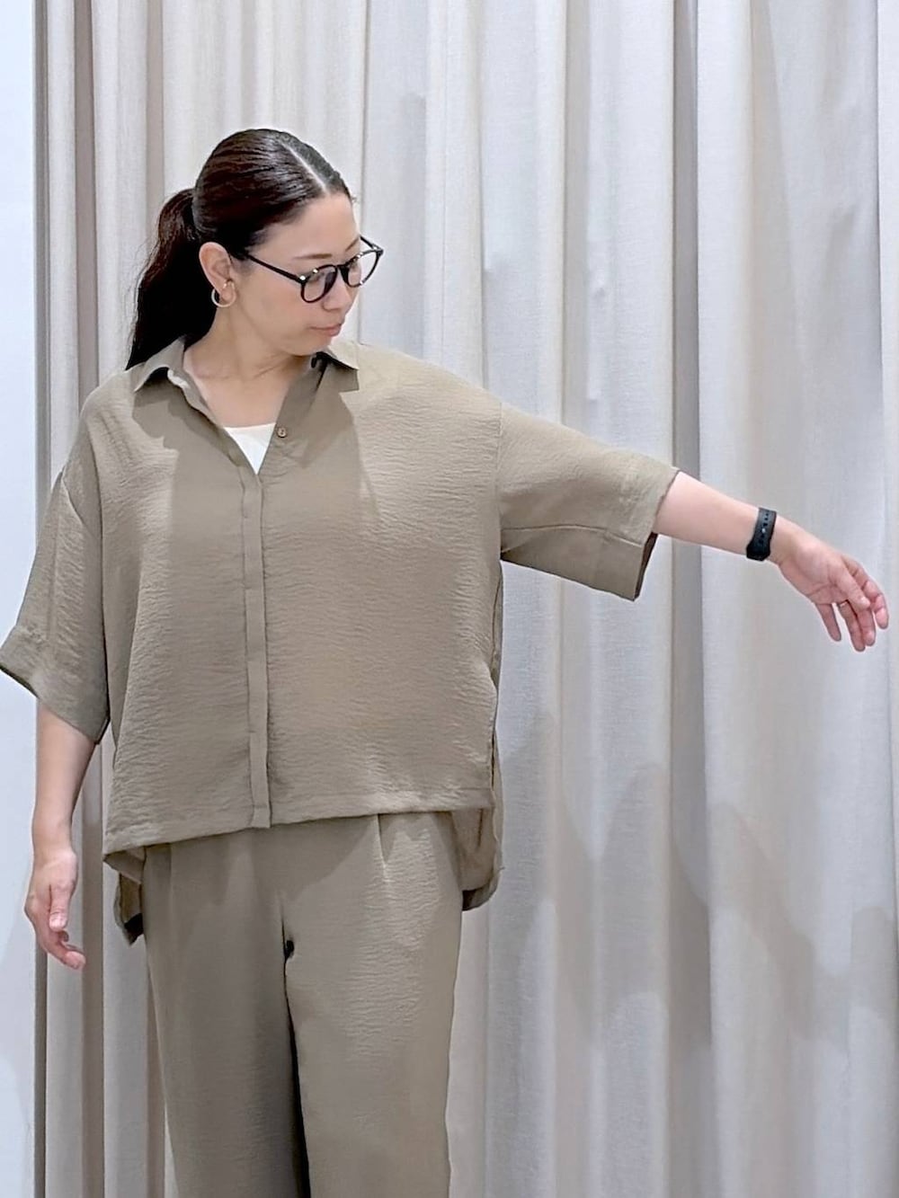 グリーン系のその他パンツ、ホワイト系のタンクトップ、ブラック系のサンダルを着用したレディースの夏コーディネートの6枚目の写真