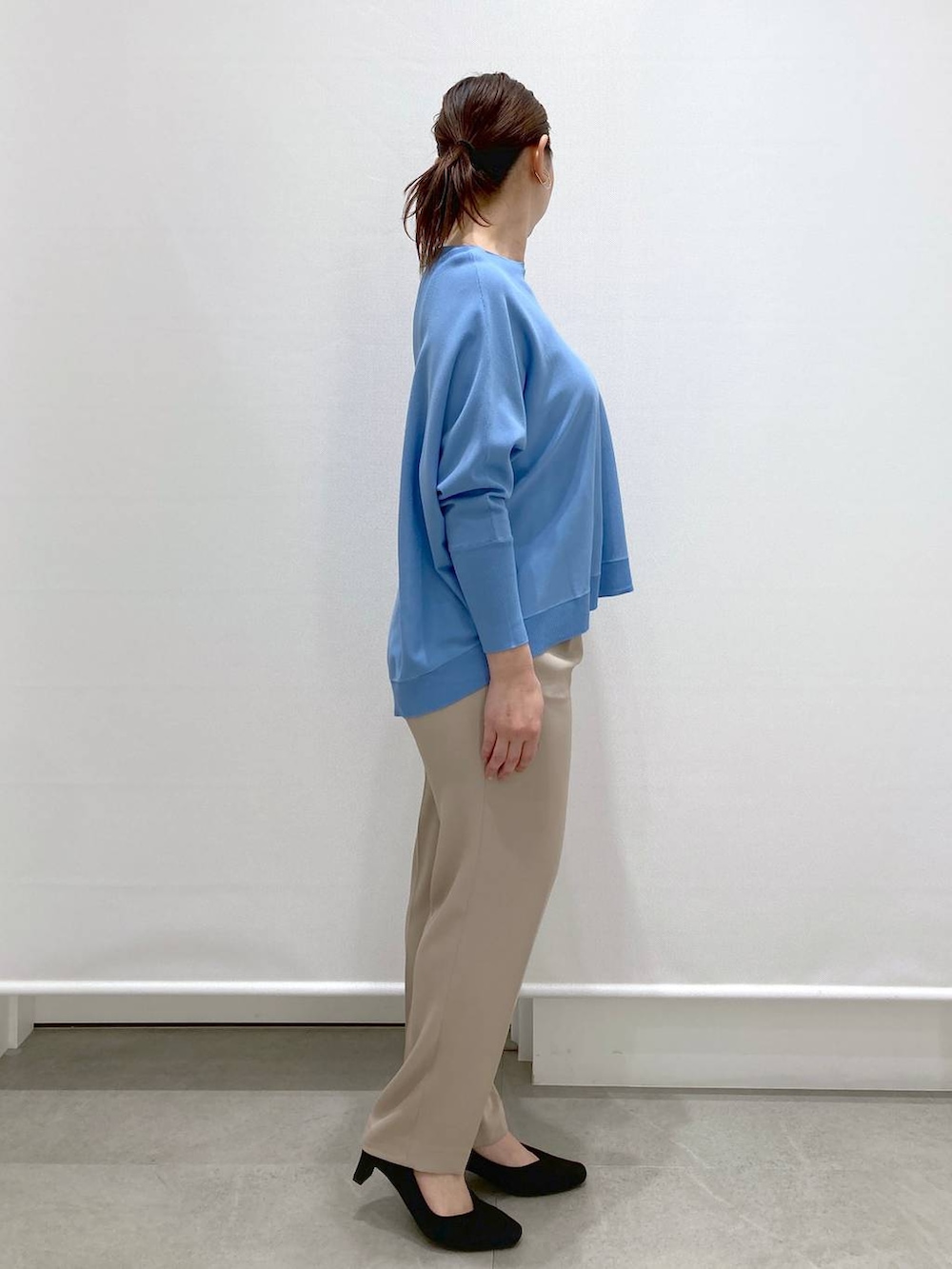 ブラック系のショルダーバッグ、ブルー系のニット/セーター、ベージュ系のその他パンツを着用したレディースの春コーディネートの5枚目の写真