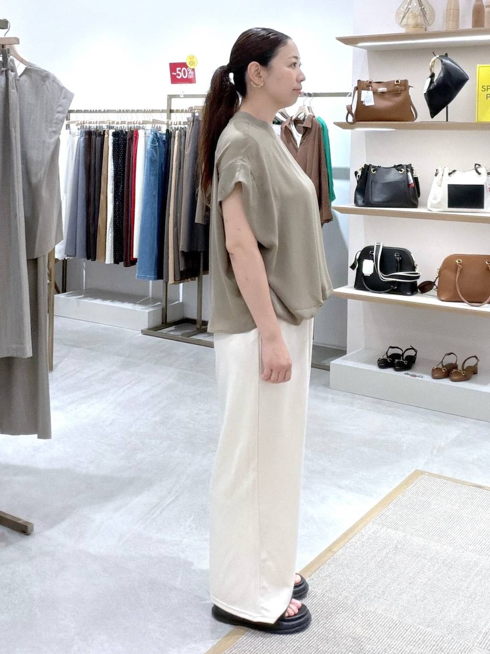 ホワイト系のその他パンツ、グリーン系のTシャツ/カットソー、ホワイト系のトートバッグを着用したレディースの夏コーディネートの3枚目の写真