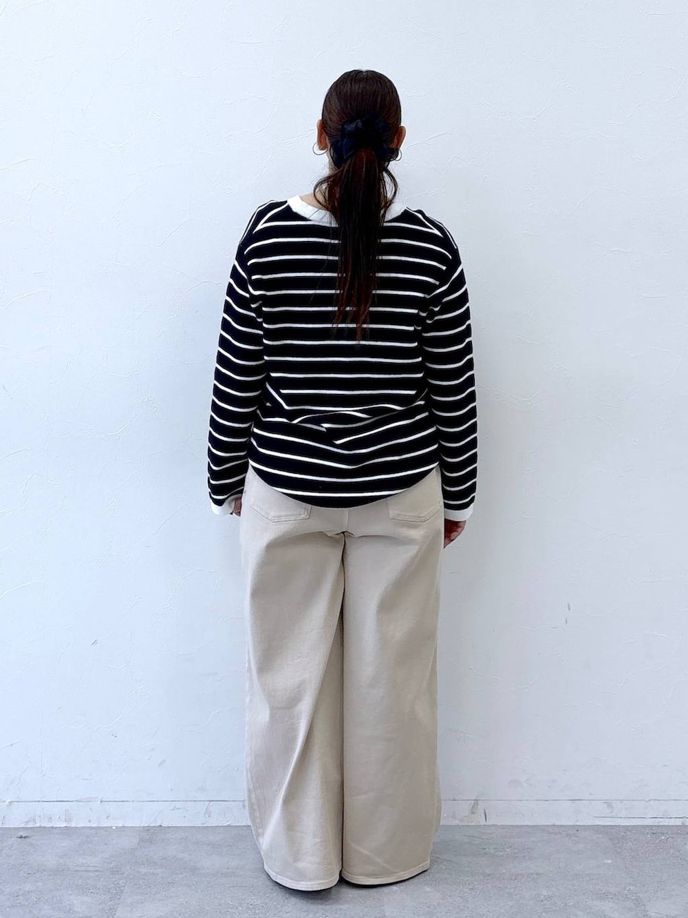 ブラック系のハンドバッグ、ベージュ系のデニムパンツ、ブラック系のカーディガン/ボレロを着用したレディースの冬コーディネートの4枚目の写真