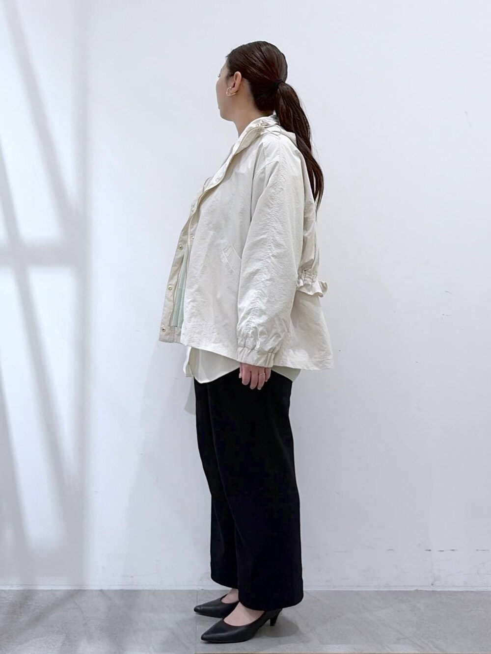 ホワイト系のその他パンツ、ブラック系のハンドバッグ、グリーン系のTシャツ/カットソーを着用したレディースの春コーディネートの3枚目の写真