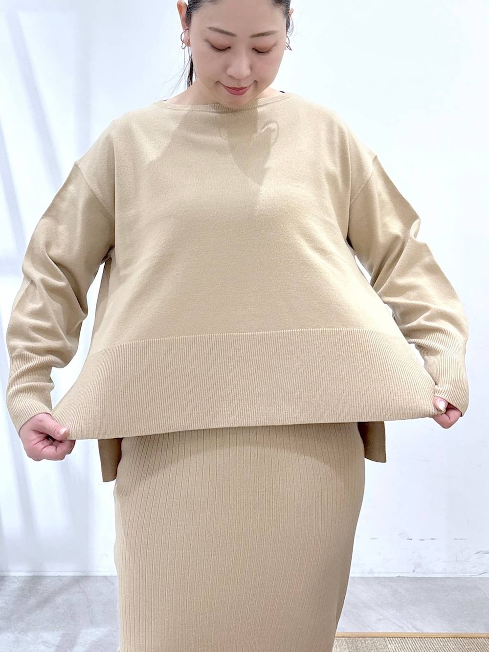 ベージュ系のニット/セーター、ベージュ系のスカート、ブラック系のパンプスを着用したレディースの冬コーディネートの6枚目の写真